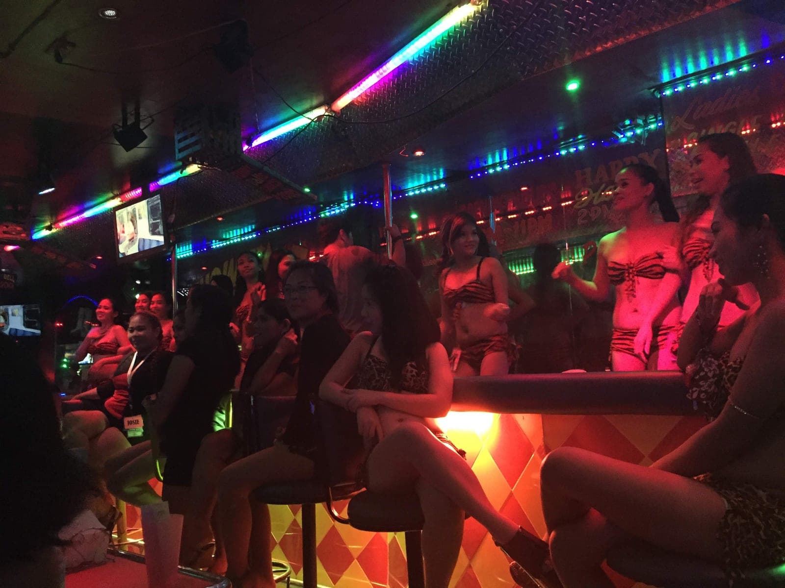 Dancers and customers along the bar rail of an Angeles City go-go bar early in the evening