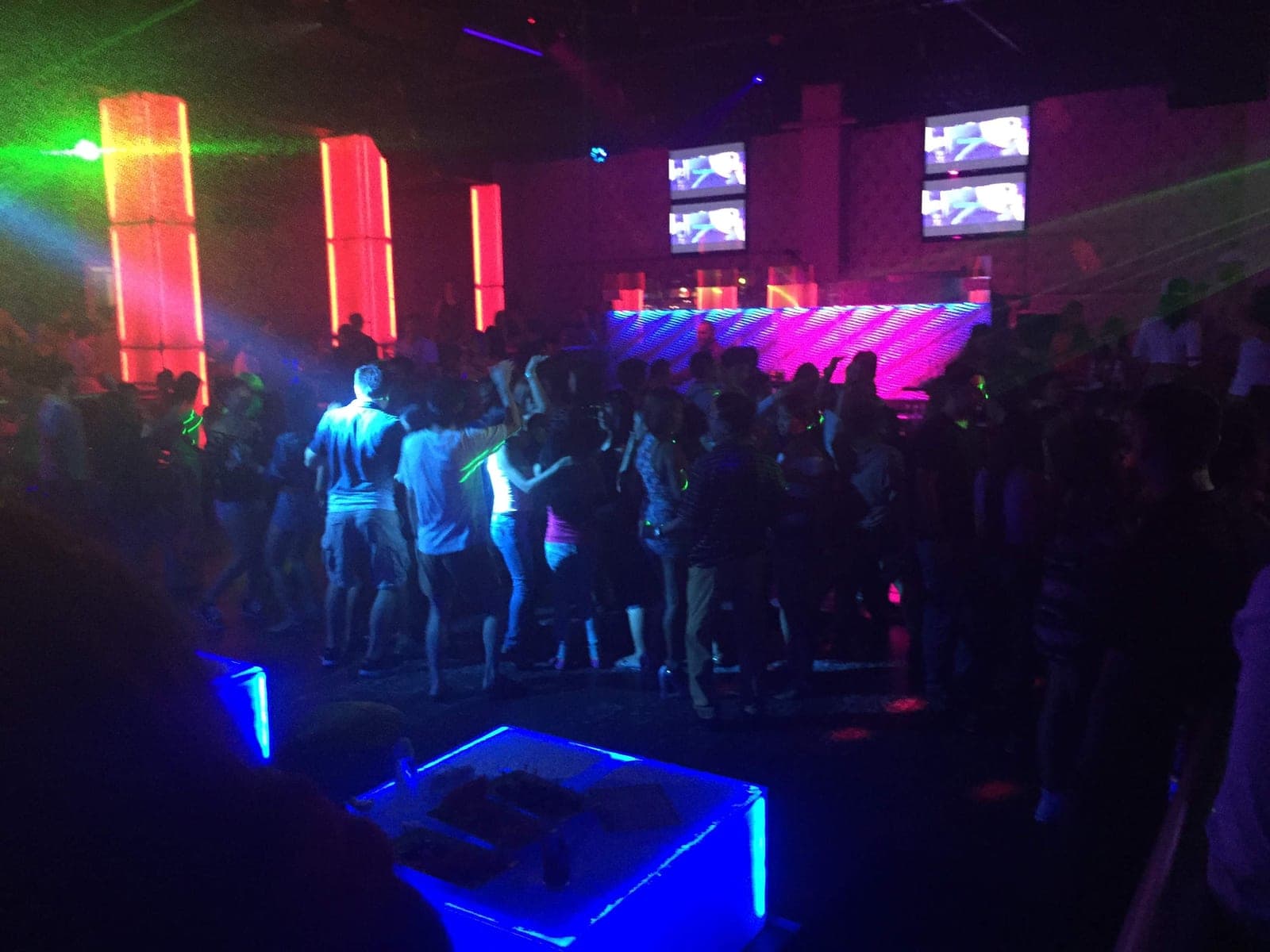 The dance floor of a large Angeles City nightclub, red light columns and an LED wall behind