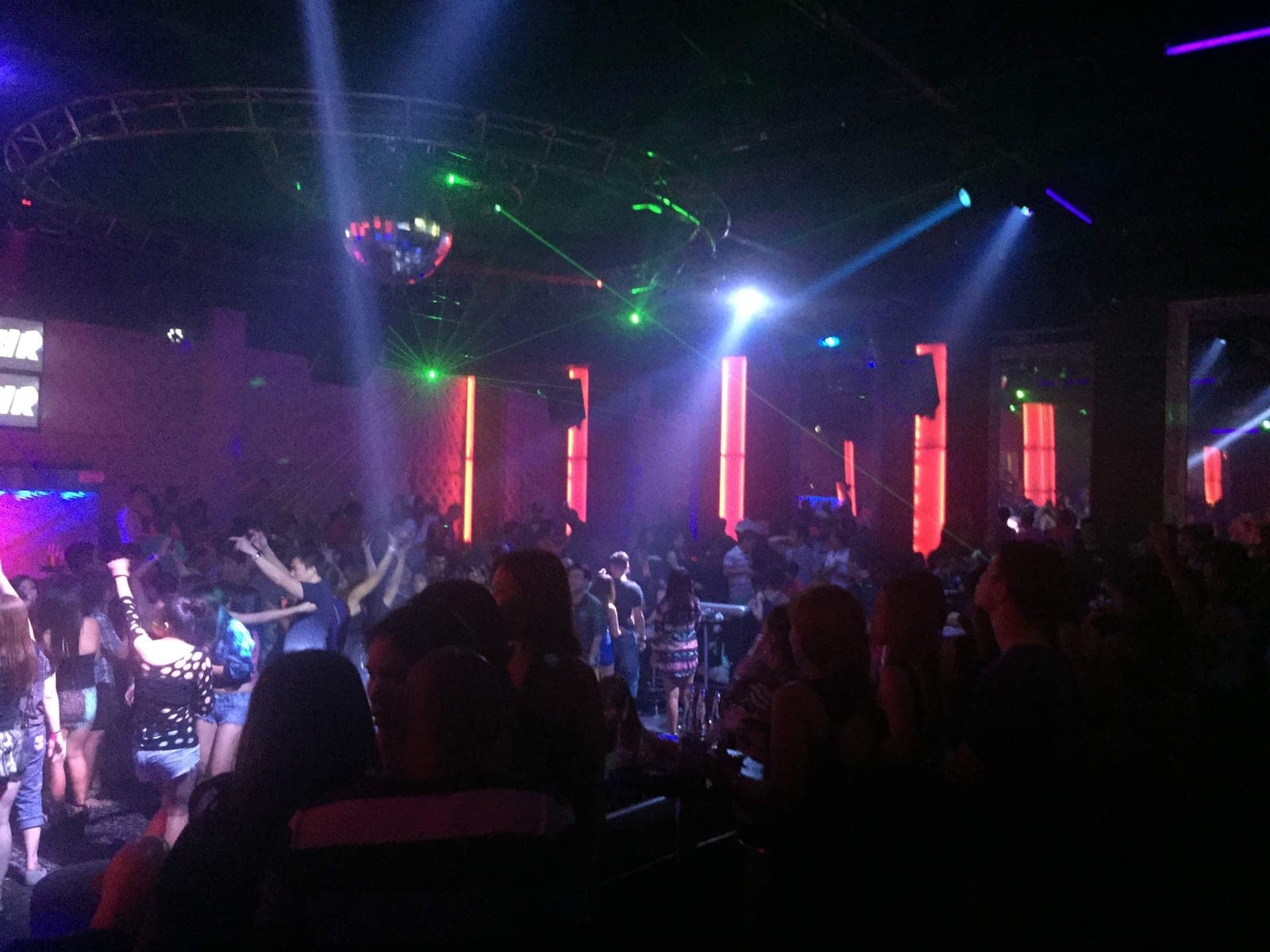 Green lasers and a mirror ball over a packed dance floor in an Angeles City nightclub at 3am