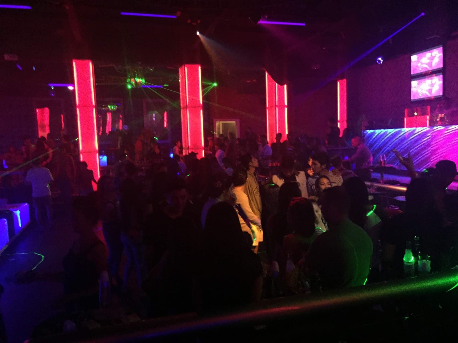 Red-lit columns and a late-night crowd inside an Angeles City nightclub