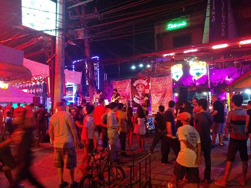 A live band playing on a stage in the middle of Walking Street, Angeles City, surrounded by a crowd